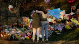 Community members embrace while visiting a memorial at the school entrance after a deadly shooting at the Covenant School in Nashville, Tennessee, U.S. March 29, 2023.