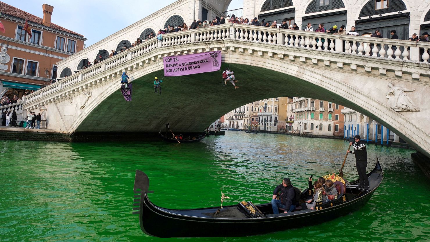 People ride in boats as waters of Grand Canal turned green after a protest by 'Extinction Rebellion' climate activists in Venice, Italy, December 9, 2023. REUTERS/Manuel Silvestri     TPX IMAGES OF THE DAY