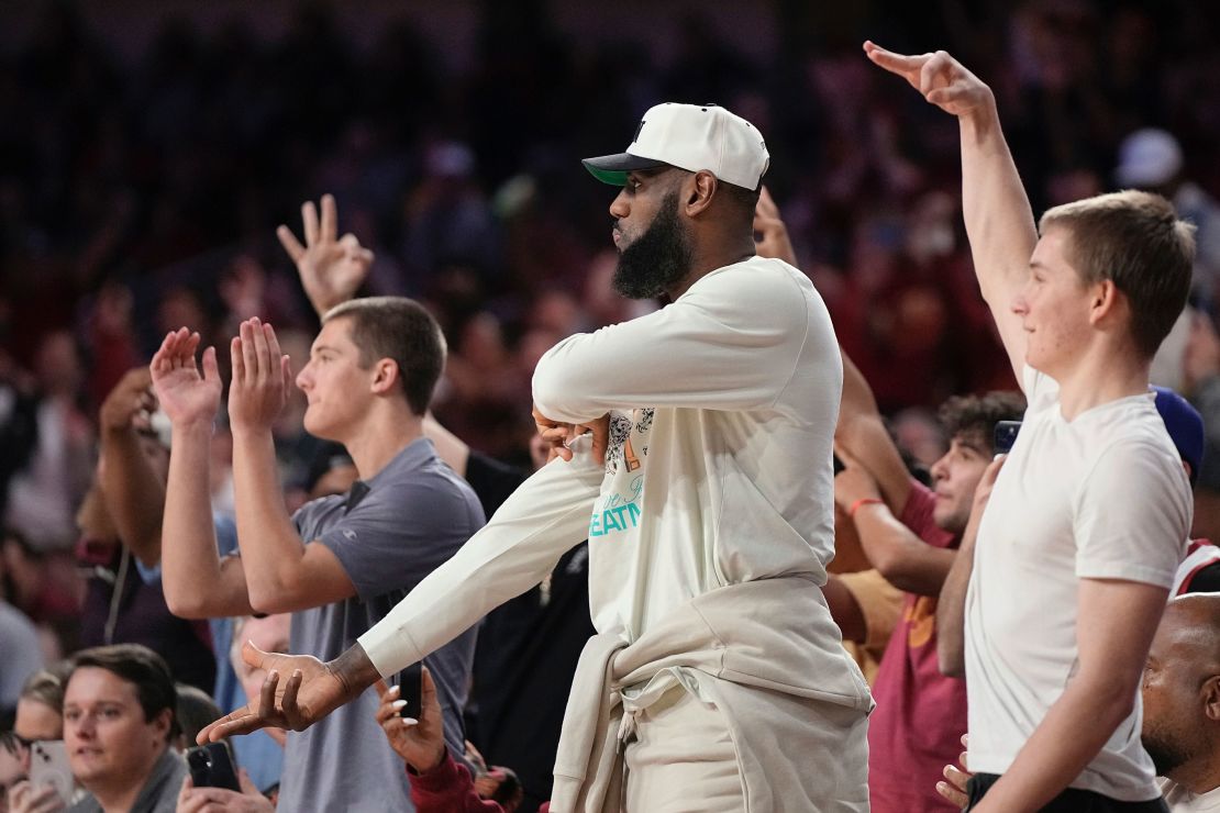 LeBron James, center, celebrates after his son, Southern California guard Bronny James, scored a three-point shot, his first college points, during the second half of an NCAA college basketball game against Long Beach State Sunday, Dec. 10, 2023, in Los Angeles. (AP Photo/Mark J. Terrill)