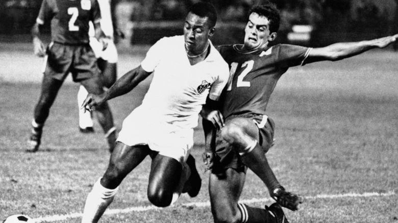 Pele, the legendary soccer star from Brazil?s Santos team, drives past Oakland Clipper (12) Trond Hoftvedt to score in the first half to deadlock the game played in the Oakland Coliseum. Pele scored again late in the second half and led Santos to a 3-1 exhibition victory over Oakland of the North American Soccer League before a record crowd. (AP Photo)