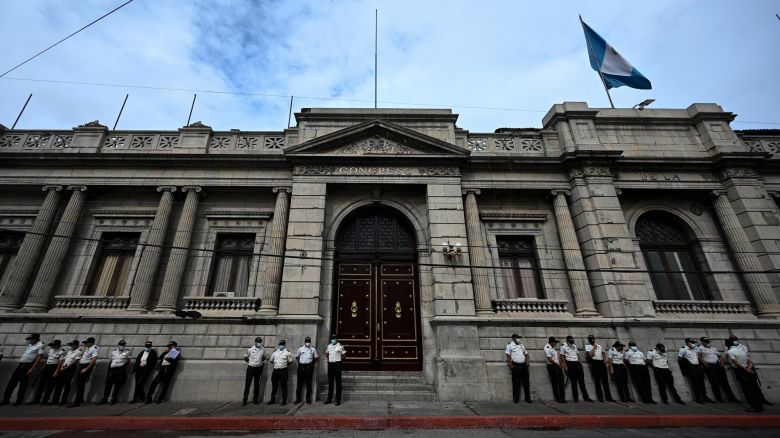 Police officers stand guard outside the Congress building, one day after former Guatemalan soldiers protested in demand of compensation for their services during the country civil war (1960-1996), in Guatemala City on October 20, 2021. - Hundreds of former Guatemalan soldiers caused damage and burnt vehicles in the center of the capital while demanding compensation for their services, as the compensation law for victims of the civil war --widows and orphans-- does not include members of the armed forces. (Photo by Johan ORDONEZ / AFP) (Photo by JOHAN ORDONEZ/AFP via Getty Images)