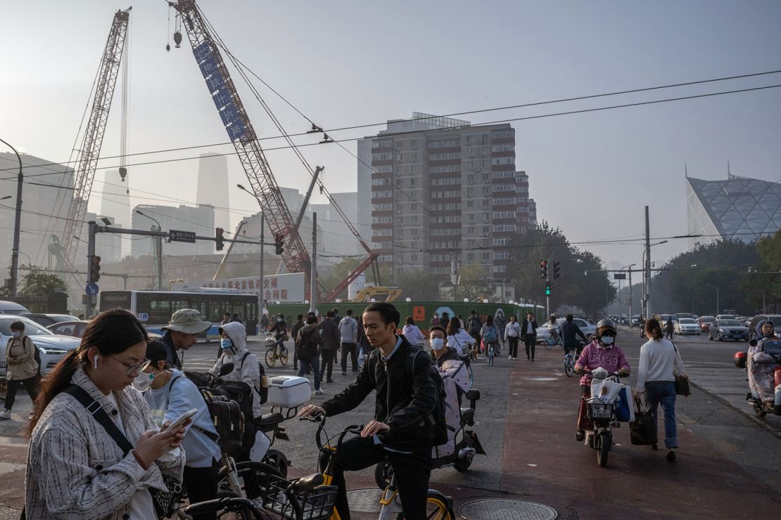 Morning commuters passing through a construction site in Beijing on October 30.