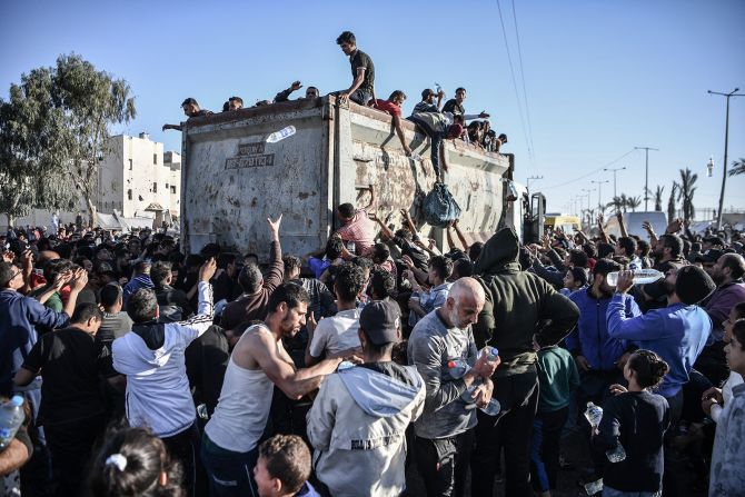 Palestinians crowd around a truck that's distributing bottles of water in Rafah, Gaza, on December 11.