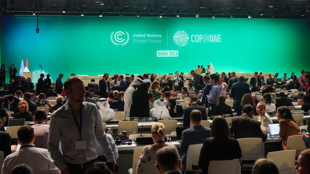 Participants arrive for a plenary session during the COP28 United Nations climate summit in Dubai on December 13, 2023. A draft UN climate deal called on December 13 for the world to transition away from fossil fuels, in a last-ditch bid to break a deadlock between nations seeking a phase-out from oil, gas and coal and Saudi-led crude producers. (Photo by Giuseppe CACACE / AFP)