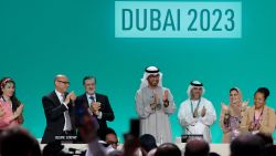 COP28 president Sultan Ahmed Al Jaber (C) applauds among other officials before a plenary session during the United Nations climate summit in Dubai on December 13, 2023. Nations adopted the first ever UN climate deal that calls for the world to transition away from fossil fuels. "We have the basis to make transformational change happen," COP28 president Sultan Al Jaber said at the UN climate summit in Dubai before the deal was adopted by consensus, prompting delegates to rise and applaud. (Photo by Giuseppe CACACE / AFP)