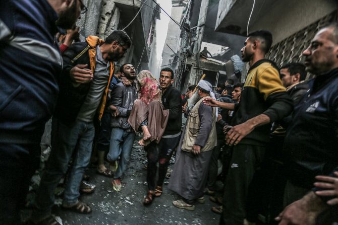 Palestinians carry an injured woman following an Israeli air strike in Rafah, Gaza, on December 12.