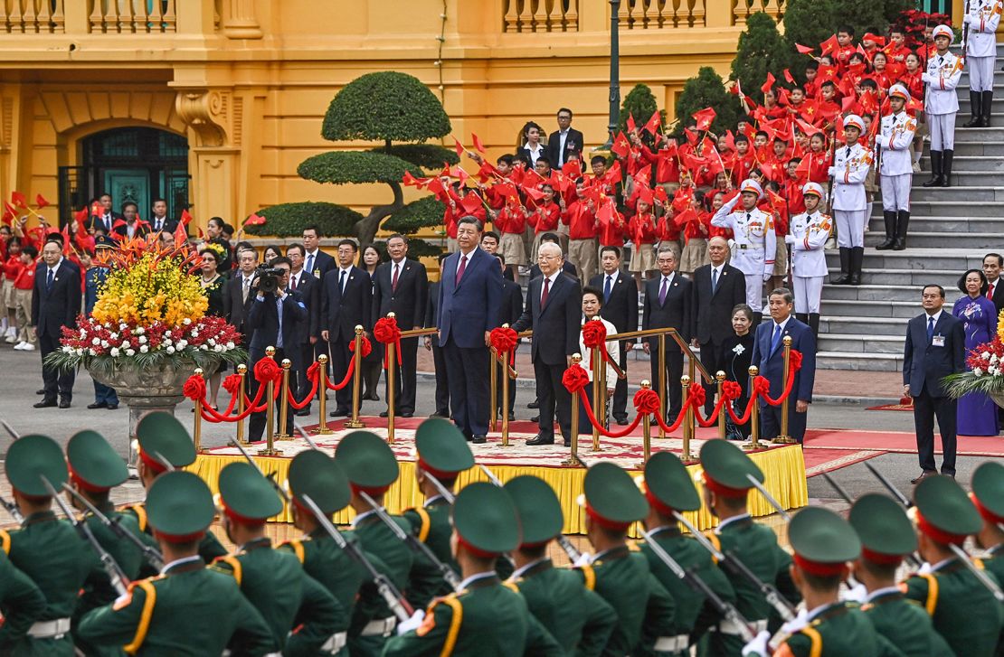 China's President Xi Jinping (centre L) and Vietnam's Communist Party General Secretary Nguyen Phu Trong (centre R) attend a welcome ceremony at the Presidential Palace in Hanoi on December 12, 2023.