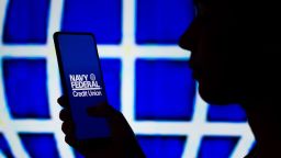 Mandatory Credit: Photo by Rafael Henrique/SOPA Images/Shutterstock (12884624q)
In this photo illustration, a woman's silhouette holds a smartphone with the Navy Federal Credit Union logo displayed on the screen and in the background.
Photo illustration in Brazil - 06 Apr 2022