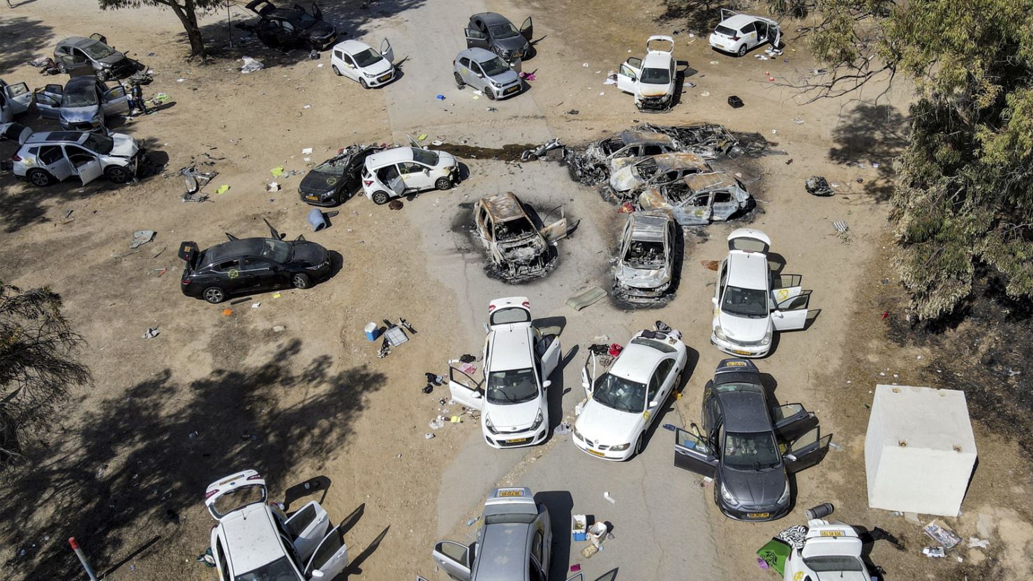 TOPSHOT - This aerial picture shows abandoned and torched vehicles at the site of the October 7 attack on the Supernova desert music Festival by Palestinian militants near Kibbutz Reim in the Negev desert in southern Israel on October 13, 2023. One month after Israel was wracked by Hamas attacks, life has been upended for both the Palestinians and Israel after it launched a war of reprisal in the Gaza Strip. The October 7 attacks by Hamas militants who stormed across from Gaza and struck kibbutzim and southern Israeli areas killed 1,400 people, mostly civilians, and deeply scarred the nation. The health ministry in Hamas-run Gaza says nearly 9,500 have been killed, two-thirds of them women and children, and mostly civilians. (Photo by Jack GUEZ / AFP) (Photo by JACK GUEZ/AFP via Getty Images)