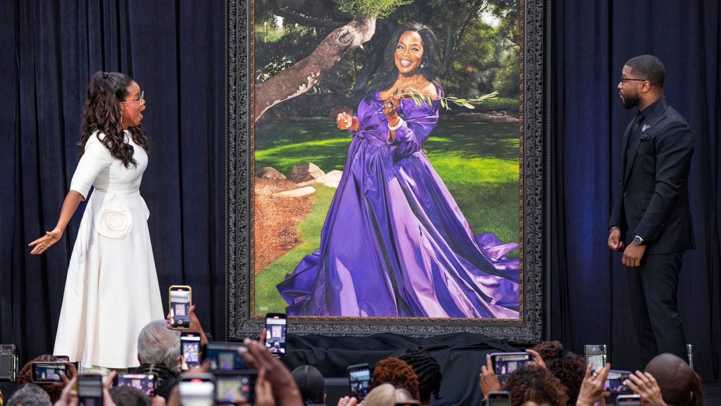 Oprah Winfrey reacts as she and artist Shawn Michael Warren, right, unveil Warren's portrait of Winfrey, Wednesday, Dec. 13, 2023, during a ceremony at the Smithsonian's National Portrait Gallery in Washington. (AP Photo/Jacquelyn Martin)
