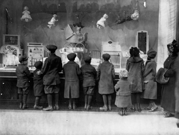 Children in New York look at a Christmas window display at Macy's that featured dolls, baby carriages and miniature furniture.
