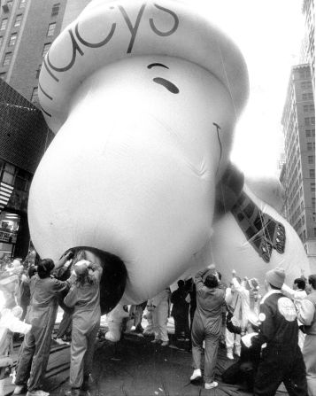 A Snoopy balloon lets off steam as workers deflate it after the Thanksgiving Day Parade in 1987.