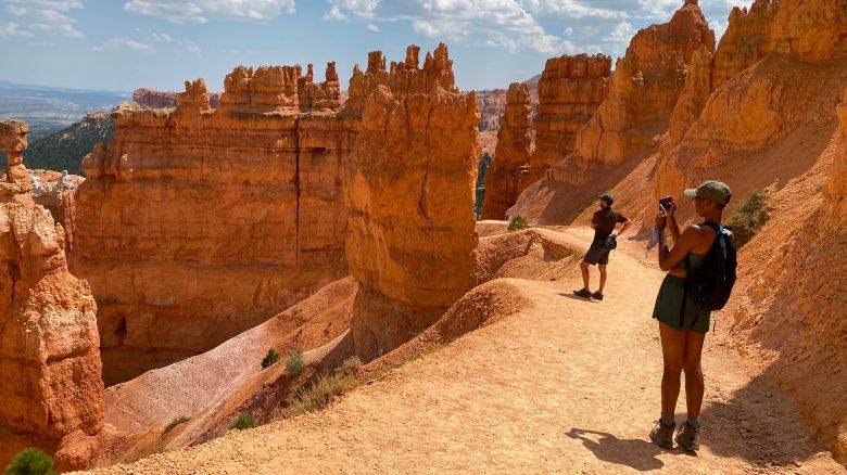 Tourists take pictures of the Temple of Osiris, a rock formation, situated at the Sunset point on the Navajo Trail of the Bryce National park, Utah on August 26, 2020. (Photo by Daniel SLIM / AFP) (Photo by DANIEL SLIM/AFP via Getty Images)