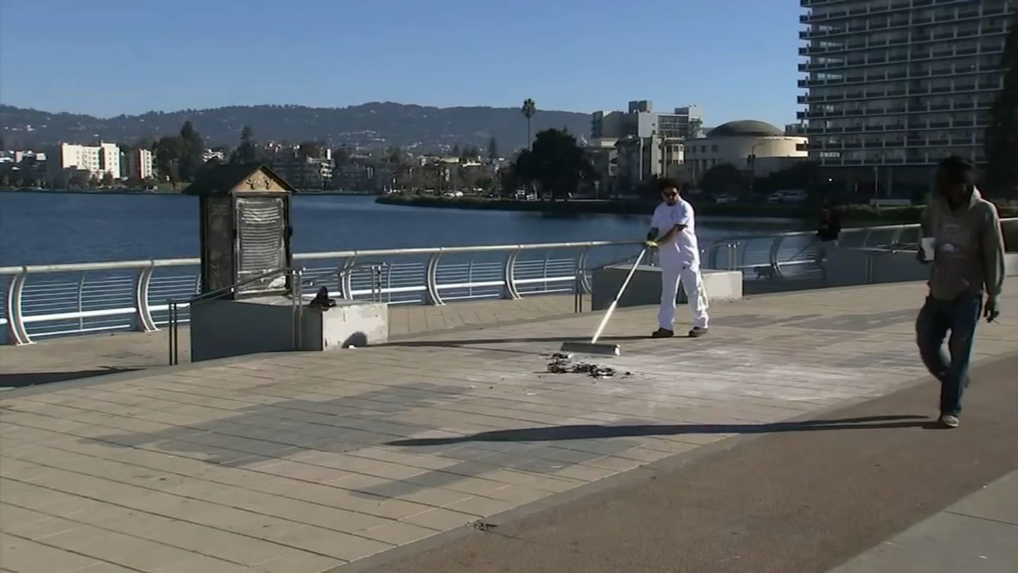 A worker cleans up the site of a destroyed menorah thrown into Lake Merritt in Oakland, California.