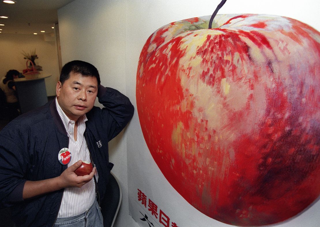 Hong Kong tycoon Jimmy Lai posing in 1995 front of a poster advertising his newly launched newspaper Apple daily.