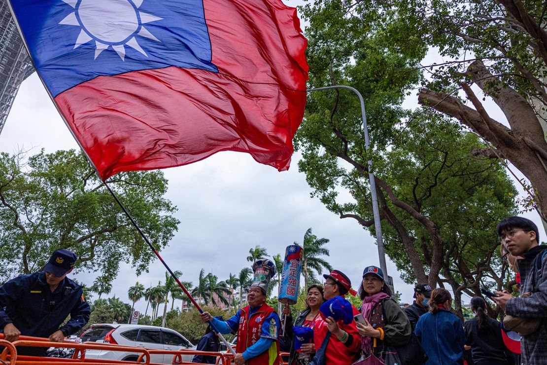 A supporter of Taiwan's opposition KMT waves a giant national flag in Taipei on November 24, 2023
