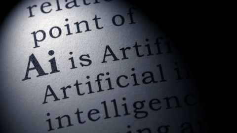 A photo illustration of a dictionary entry on AI, or artificial intelligence.