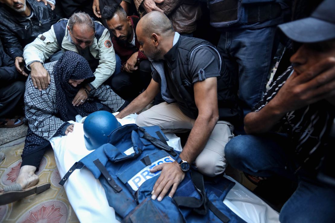 KHAN YUNIS, GAZA - DECEMBER 16: (Editor's note: Image depicts death.) Relatives and friends bid farewell to the body of Al Jazeera cameraman Samer Abu Daqqa, who was killed while working in an air strike, on December 16, 2023 in Khan Yunis, Gaza. World Health Organisation's Executive Board adopted a rare resolution on access for life-saving aid into Gaza and respect for laws of war, with the UN health chief reiterating an immediate ceasefire as "nowhere and no one is safe" in Gaza. (Photo by Ahmad Hasaballah/Getty Images)