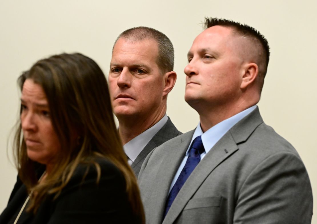 BRIGHTON, CO - JANUARY 20: Paramedics Peter Cichuniec, center, and Jeremy Cooper, right, listen to attorney Shana Beggan at an arraignment in the Adams County district court at the Adams County Justice Center January 20, 2023.