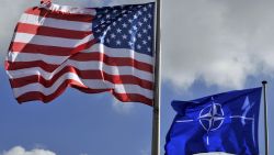 A picture taken on March 2, 2014 shows the US and NATO flags in the wind at the NATO headquarters in Brussels. AFP PHOTO / GEORGES GOBET (Photo by Georges GOBET / AFP) (Photo by GEORGES GOBET/AFP via Getty Images)