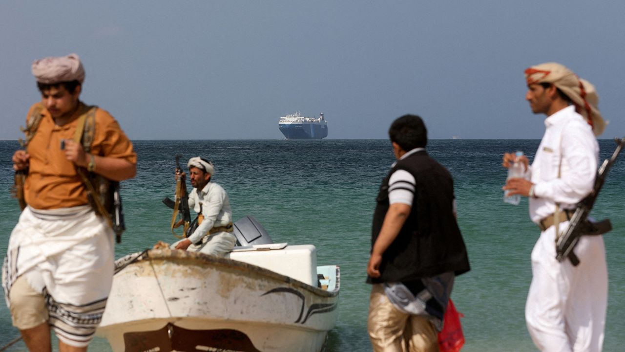 FILE PHOTO: Armed men stand on the beach as the Galaxy Leader commercial ship, seized by Yemen's Houthis last month, is anchored off the coast of al-Salif, Yemen, December 5, 2023. REUTERS/Khaled Abdullah/File Photo