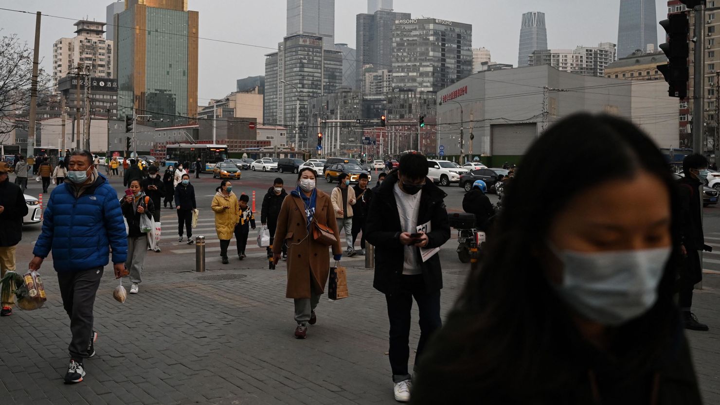 People walk on a street at the end of the workday in Beijing on March 17, 2023. (Photo by GREG BAKER / AFP) (Photo by GREG BAKER/AFP via Getty Images)
