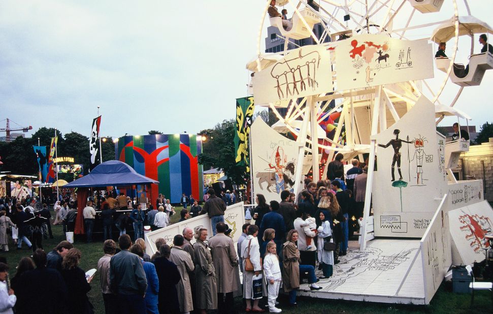 Visitors line up for a ride on a Ferris wheel painted designs by Jean-Michel Basquiat. © Estate of Jean-Michel Basquiat/licensed by Artestar, New York. 