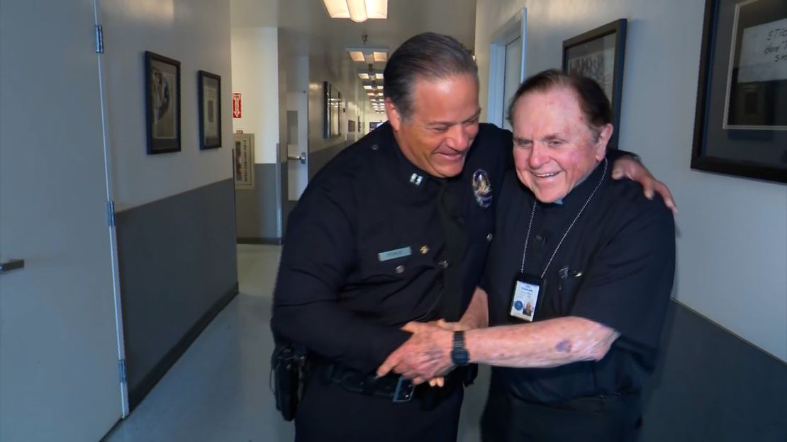 Los Angeles Police Dept. Cpt. Aaron Ponce, left, shakes hands with Monsignor Frank Hicks of the LAPD Chaplain Corps.