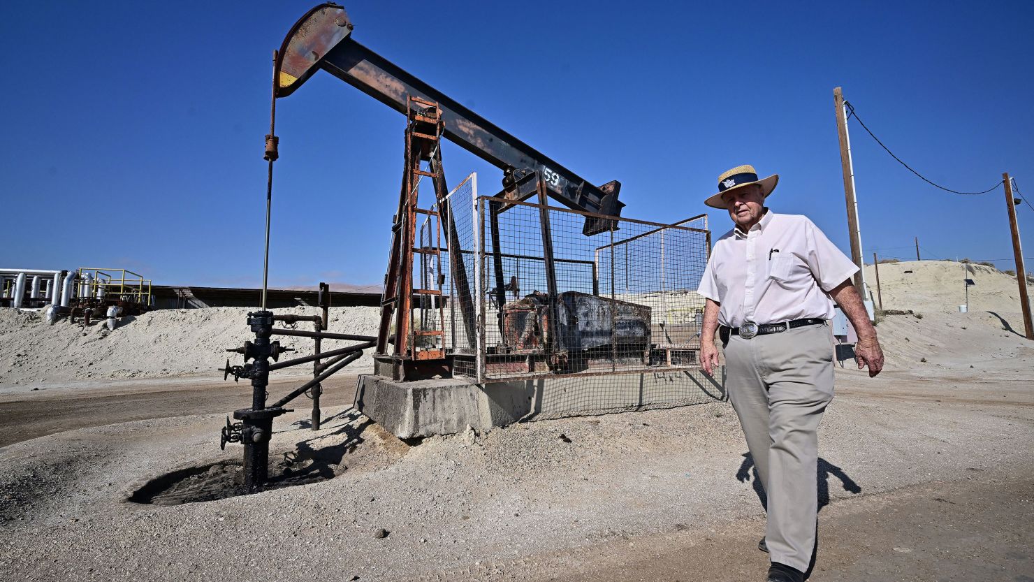 Third-generation oilman Fred Holmes walks past a working pumpjack at his oilfield in Taft, Kern County, California on September 21, 2023. California produces 311,000 barrels of crude oil every day, around 2.4 percent of all US production, making it the seventh largest producing state in the union. But it is also at the leading edge of environmentalism in the United States, and is determined to shrink its dependency. (Photo by Frederic J. BROWN / AFP) (Photo by FREDERIC J. BROWN/AFP via Getty Images)
