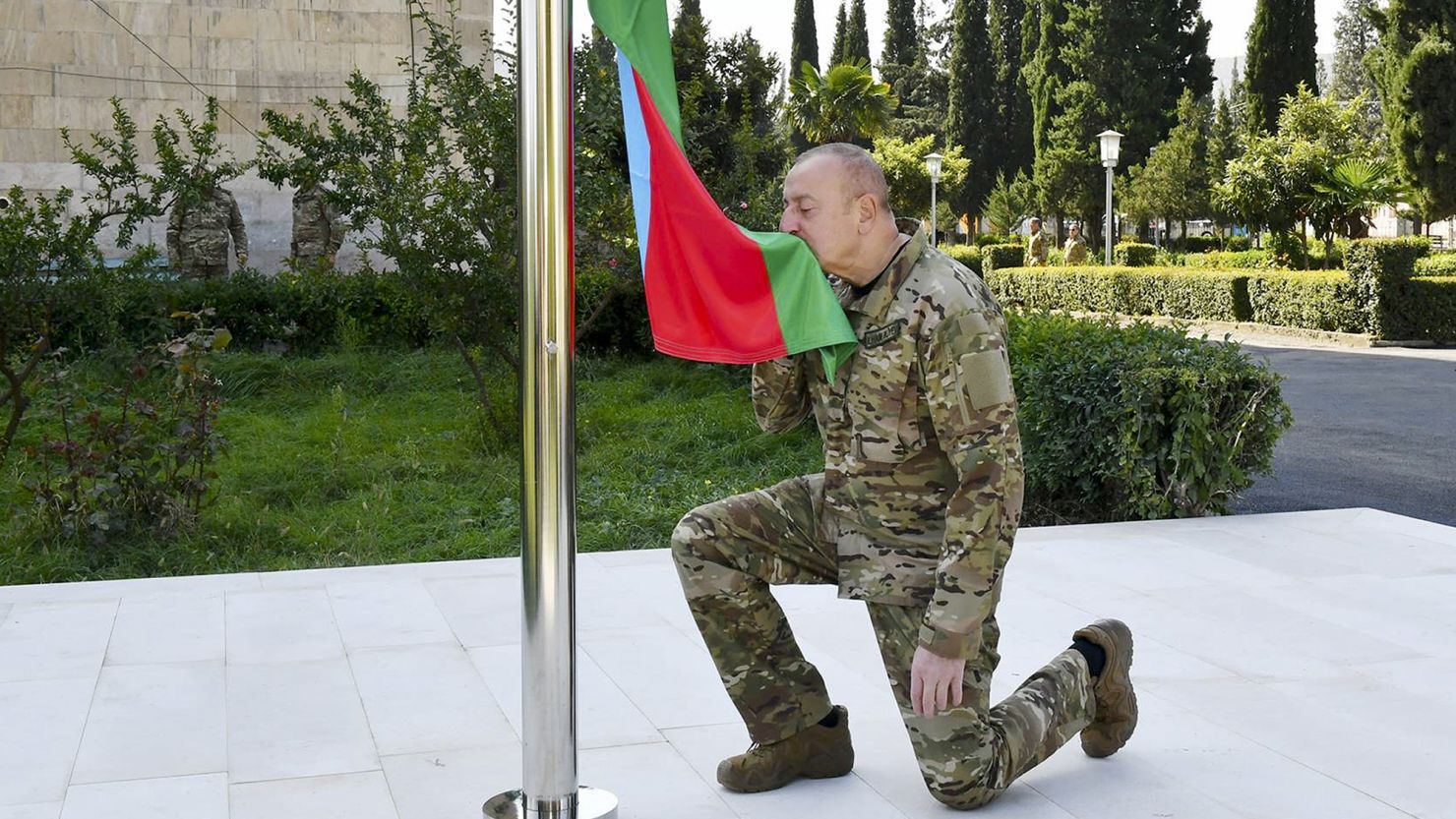 In this photo provided by Azerbaijan's Presidential Press Office on Sunday, Oct. 15, 2023, Azerbaijani President Ilham Aliyev kisses a Azerbaijani National Flag in the city of Aghdara also known as Mardakert to Armenians in Aghdara, Azerbaijan. Aliyev has raised his nation's flag over the capital of Karabakh in a ceremony reaffirming Baku's control of the disputed region. (Azerbaijani Presidential Press Office via AP)