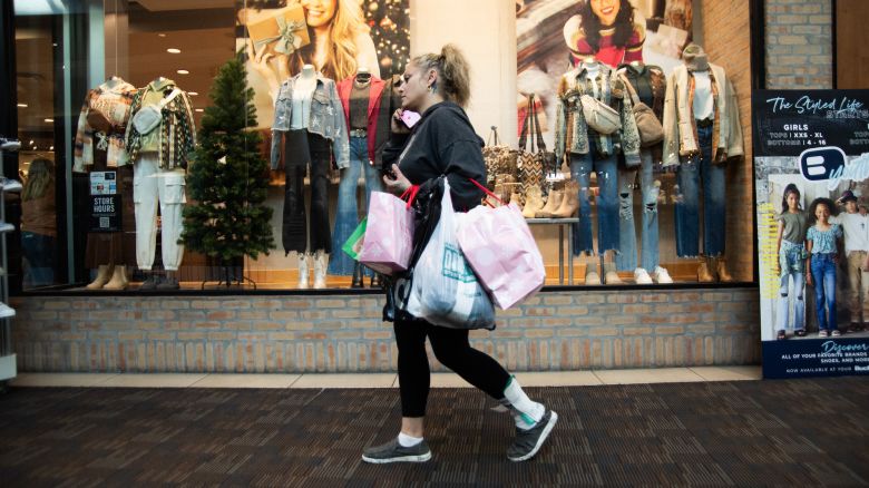 A shopper carries bags at the Polaris Fashion Place mall on Black Friday in Columbus, Ohio, US, on Friday, Nov. 24, 2023. An estimated 182 million people are planning to shop from Thanksgiving Day through Cyber Monday, the most since 2017, according to the National Retail Federation. Photographer: Matthew Hatcher/Bloomberg