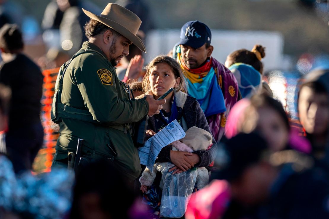 EAGLE PASS, TEXAS - DECEMBER 19: A U.S. Border Patrol agent speaks with immigrants at a transit center near the U.S.-Mexico border on December 19, 2023 in Eagle Pass, Texas. Most had crossed the Rio Grande from Mexico the night before, part of a major surge that has overwhelmed U.S. border authorities in recent weeks. (Photo by John Moore/Getty Images)