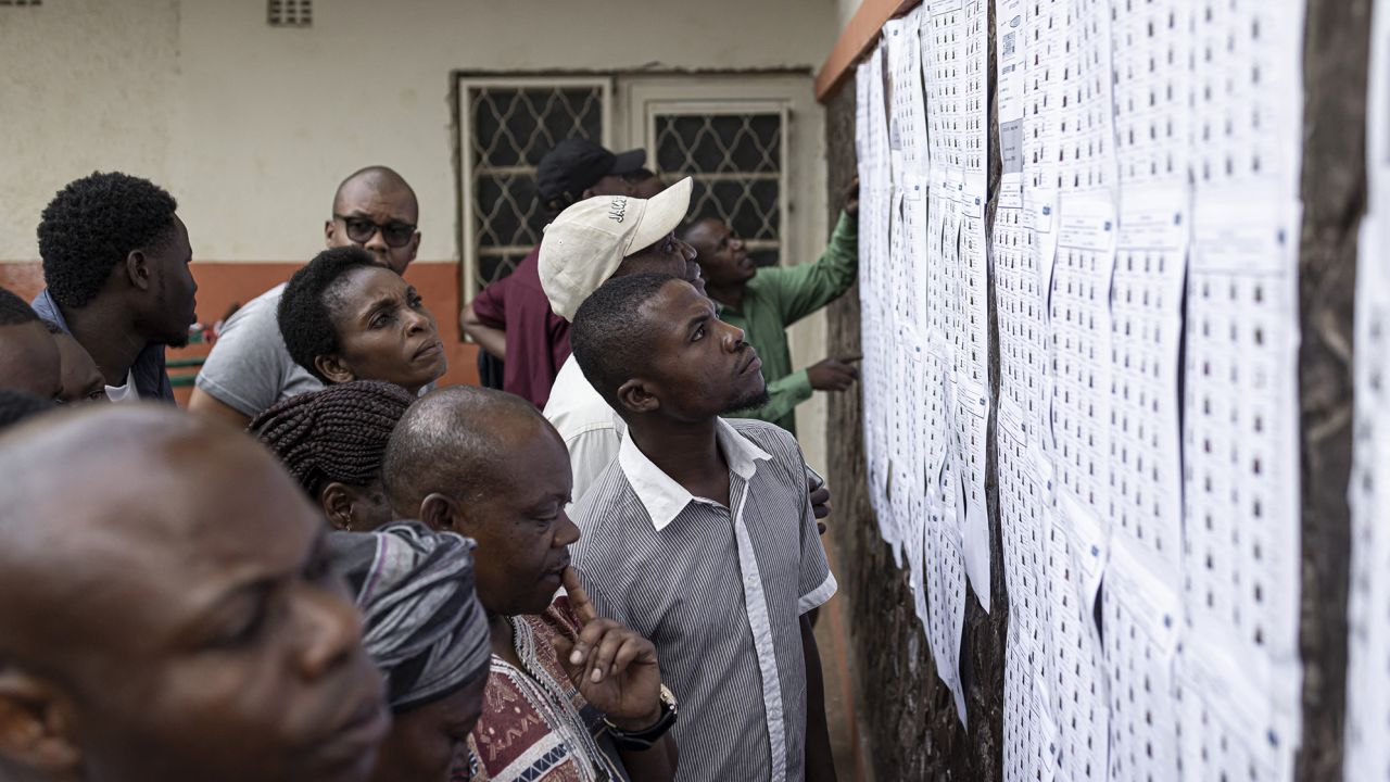 TOPSHOT - Voters look for their names on an electoral roll in a polling station at the Imara College in Lubumbashi on December 20, 2023. Millions of Congolese head to the polls on December 20, 2023 in a high-stakes presidential election pitting the incumbent President Felix Tshisekedi against a fragmented opposition. (Photo by Patrick Meinhardt / AFP) (Photo by PATRICK MEINHARDT/AFP via Getty Images)