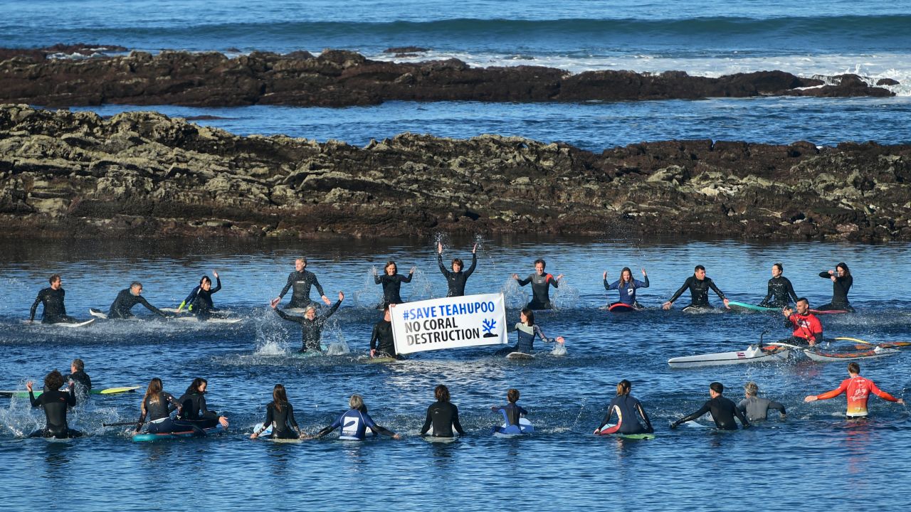 TOPSHOT - Surfers gather during a demonstration called by "Rame pour ta planete" collective to protest against the development of the Olympic surfing venue in Polynesia and to preserve the Teahupoo site, in Guethary, southwestern France, on December 17, 2023. (Photo by GAIZKA IROZ / AFP) (Photo by GAIZKA IROZ/AFP via Getty Images)