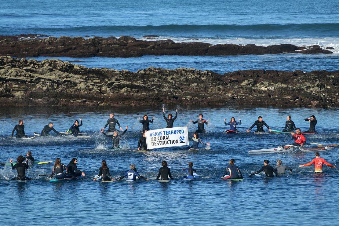 TOPSHOT - Surfers gather during a demonstration called by "Rame pour ta planete" collective to protest against the development of the Olympic surfing venue in Polynesia and to preserve the Teahupoo site, in Guethary, southwestern France, on December 17, 2023. (Photo by GAIZKA IROZ / AFP) (Photo by GAIZKA IROZ/AFP via Getty Images)