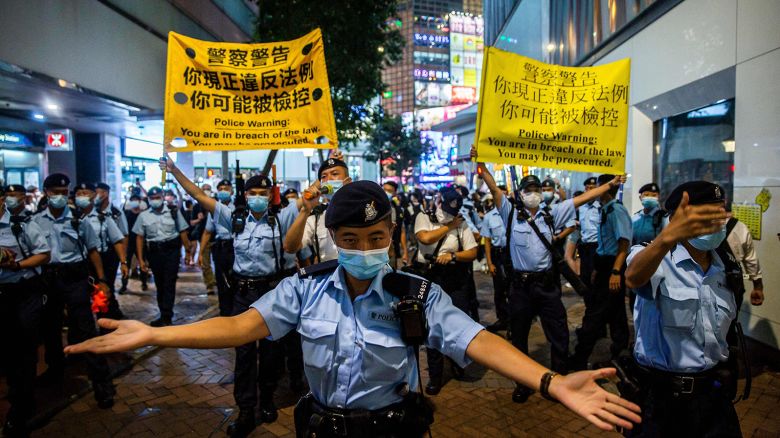Police move people on as they gathered in the Causeway Bay district of Hong Kong on June 4, 2021, after police closed the venue where Hong Kong people traditionally gather annually to mourn the victims of China's Tiananmen Square crackdown in 1989 which the authorities have banned citing the coronavirus pandemic and vowed to stamp out any protests on the anniversary.