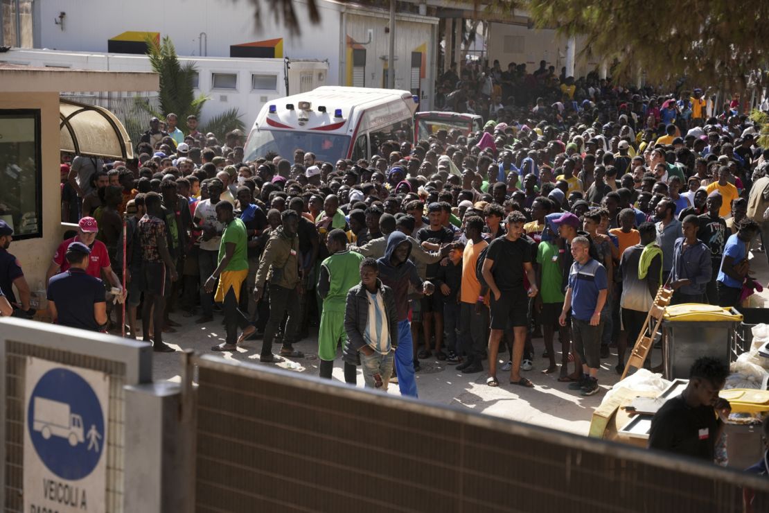 TOPSHOT - Migrants wait at the operational centre called the "Hotspot" to receive registration papers from the Red Cross on the Italian island of Lampedusa, on September 17, 2023. The European Union presented on September 17, 2023, an emergency plan for Italy to help it handle migrant arrivals after a record number of people landed on its island of Lampedusa over the past week. Since a week, around 8,500 people -- more than the island's entire local population -- have arrived in around 200 boats, according to the UN migration agency. (Photo by Zakaria ABDELKAFI / AFP) (Photo by ZAKARIA ABDELKAFI/AFP via Getty Images)