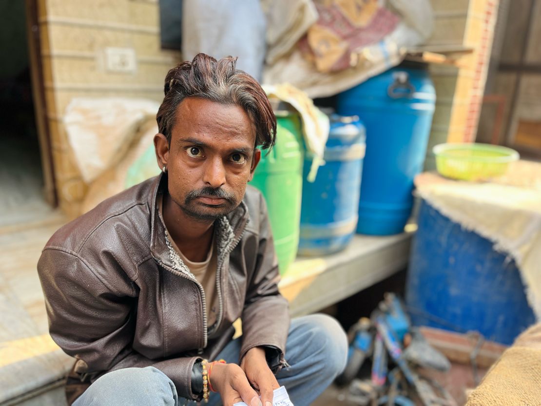 Ramesh sits outside his flat in Delhi.