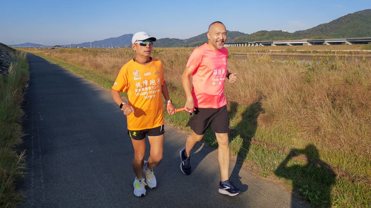 Gary Leung runs alongside a guide runner.