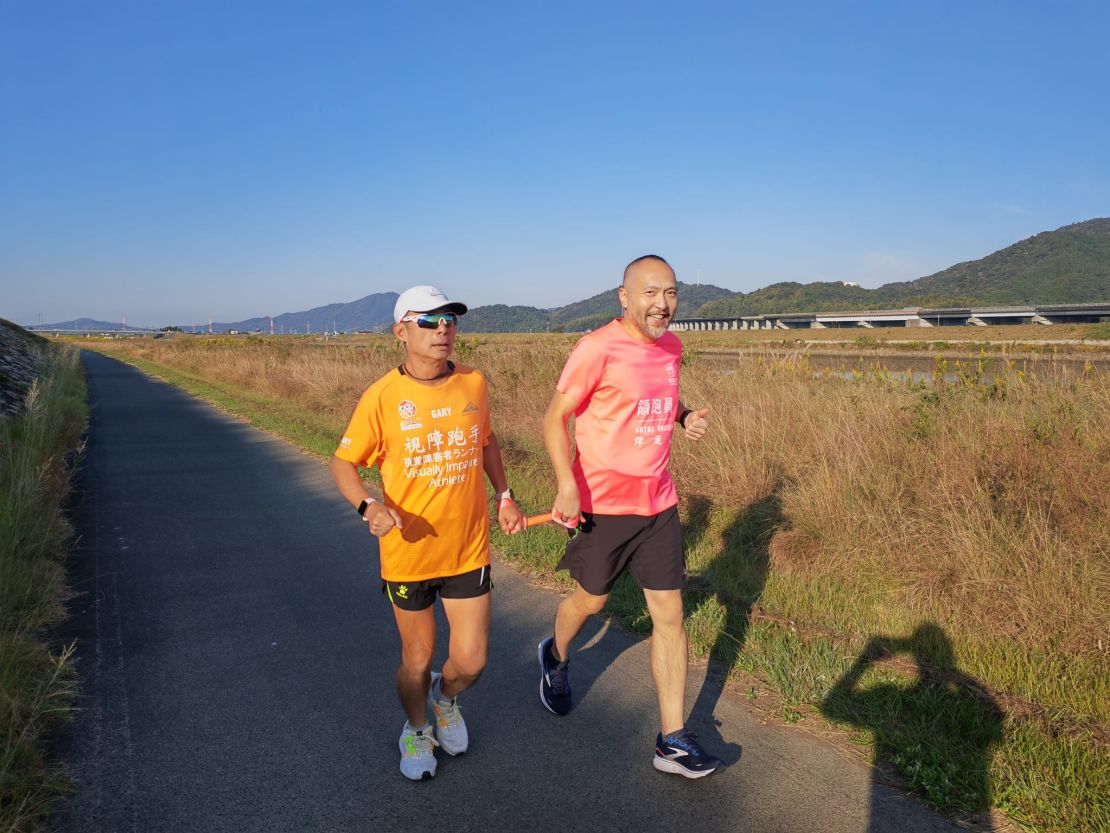 Gary Leung runs alongside a guide runner.