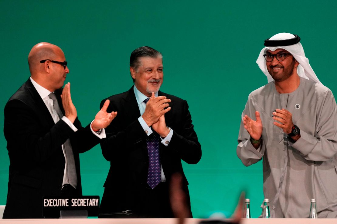 COP28 President Sultan al-Jaber, right, celebrates passing the global stocktake with United Nations Climate Chief Simon Stiell, left, and COP28 CEO Adnan Amin during a plenary session at the COP28 U.N. Climate Summit, Wednesday, Dec. 13, 2023, in Dubai, United Arab Emirates.