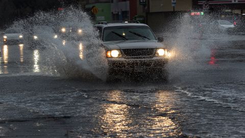 NORTH HOLLYWOOD, CA-DECEMBER 20, 2023:A motorist creates a big splash while driving thru a partially flooded Riverside Dr. In North Hollywood. The first of two storm systems is bringing rain to the Southland today.  (Mel Melcon / Los Angeles Times via Getty Images)