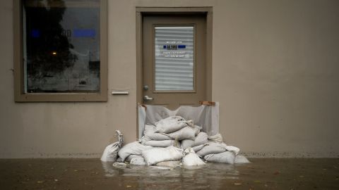 Sand bags are placed in front of a business as flood waters rise during a rainstorm, Thursday, Dec. 21, 2023, in Santa Barbara, Calif. (AP Photo/Jae C. Hong)