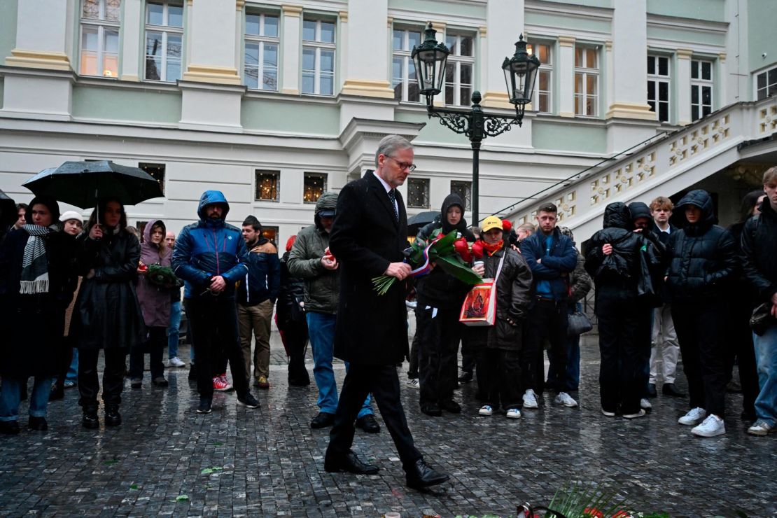 The Czech Republic's Prime Minister Petr Fiala lays flowers outside Charles University. 