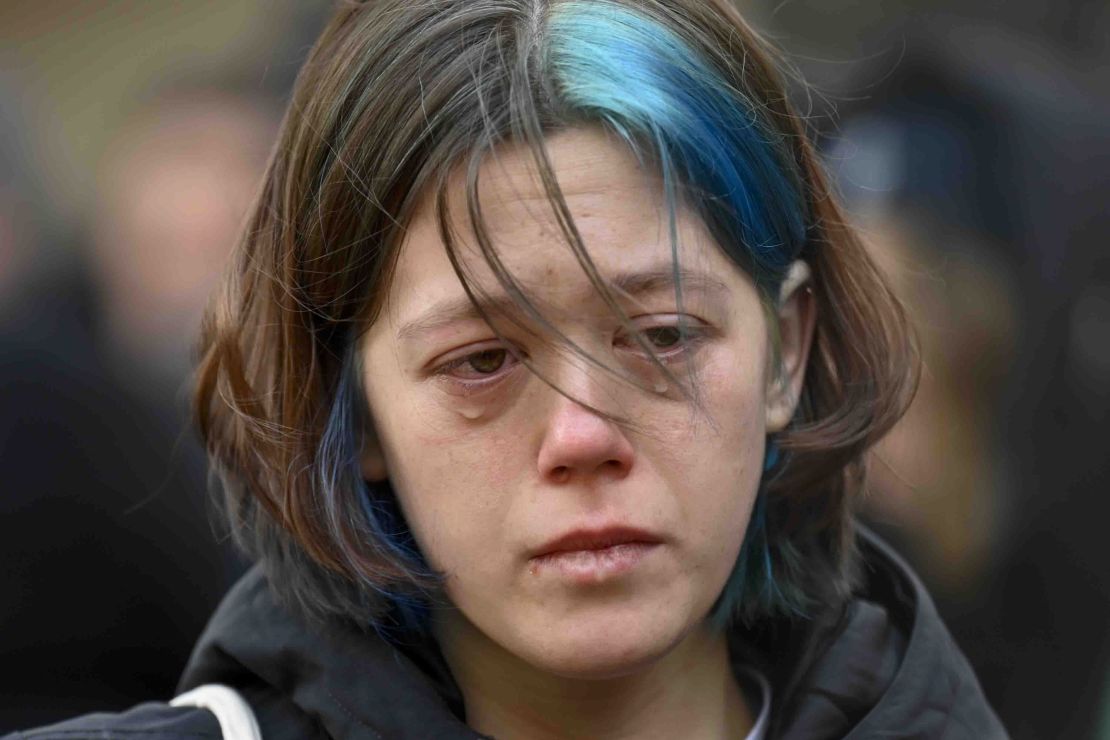 A woman cries outside the headquarters of Charles University for the victims of mass shooting in Prague, Czech Republic, Friday, Dec. 22, 2023.