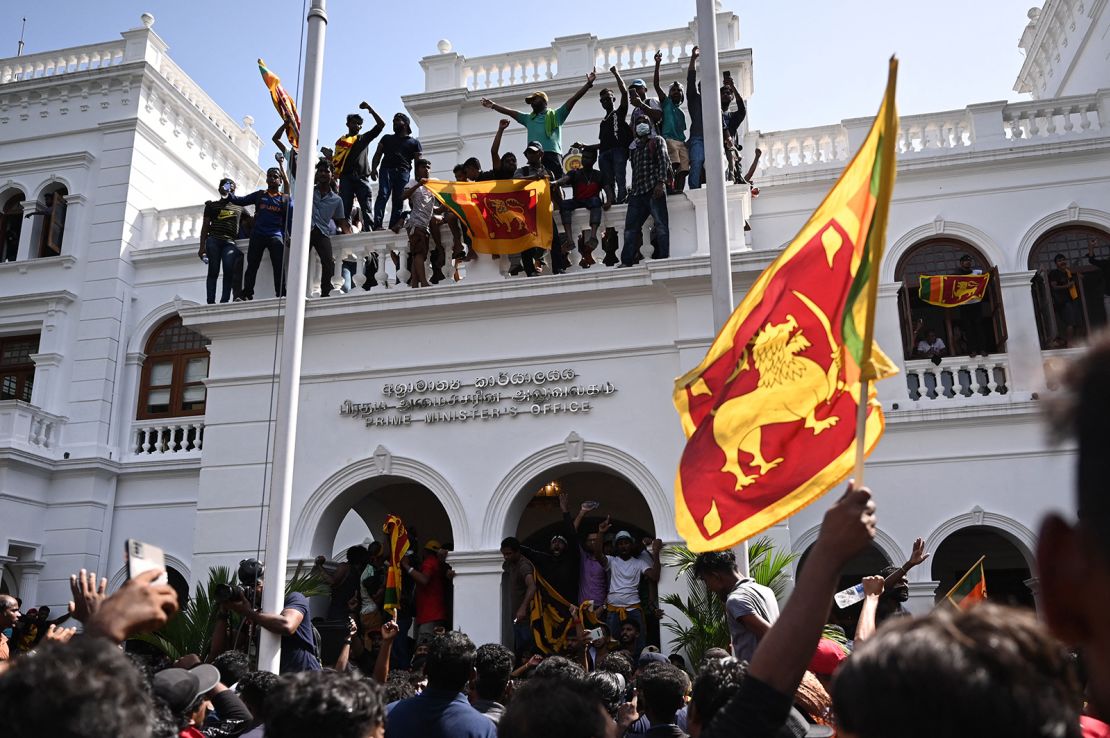 Demonstrators shout slogans and wave Sri Lankan flags during an anti-government protest inside the office building of Sri Lanka's prime minister in Colombo on July 13, 2022.