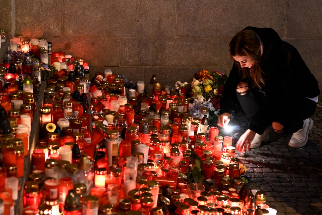 Mourners bring flowers and candles outside the building of Philosophical Faculty of Charles University in downtown Prague, Czech Republic, Saturday, Dec. 23, 2023. A lone gunman opened fire at a university on Thursday, killing more than a dozen people and injuring scores of people. (AP Photo/Denes Erdos)