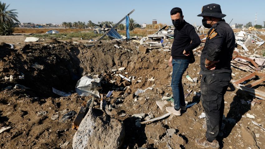 A fighter of the Iraqi Kataib Hezbollah militia group and a man inspect the site of a U.S. airstrike, in Hilla, Iraq December 26, 2023. REUTERS/Alaa al-Marjani