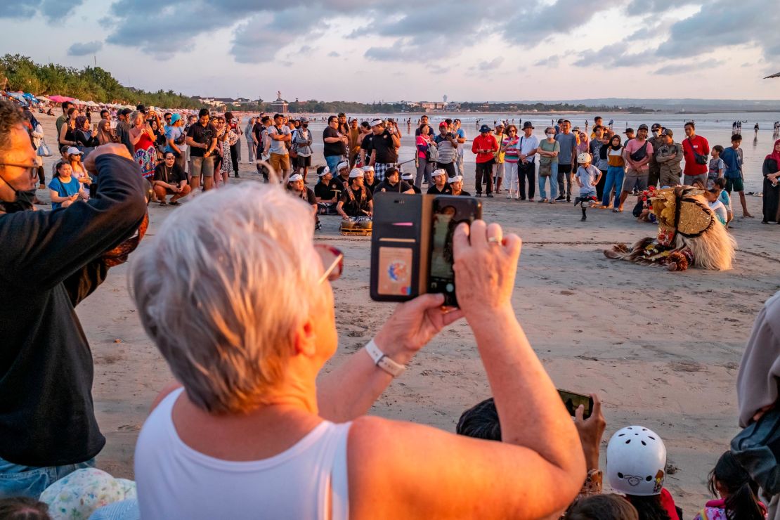 Foreign tourists watch an art performance at a beach in Kuta, Bali, Indonesia, 02 October 2023.
