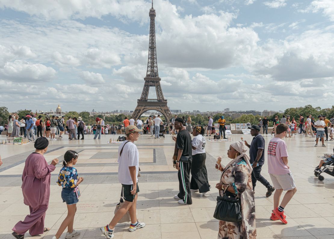 Tourists eating ice creams on the Place du Trocadero in front of the Eiffel Tower in central Paris, France, on Monday, Aug. 14, 2023.